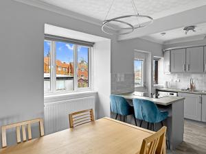 a kitchen with a dining table and blue chairs at Modern Contractor House - Lockable Gated Parking in Kiveton Park