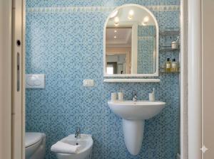 a blue tiled bathroom with a sink and a mirror at PIOPPETO EST - Premium Villas in Giulianova +2 photos