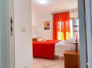 a bedroom with a bed with a red blanket and a window at PIOPPETO EST - Premium Villas in Giulianova