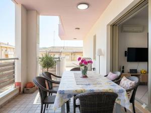 a table with chairs and a vase of flowers on a balcony at PIOPPETO EST - Premium Villas in Giulianova