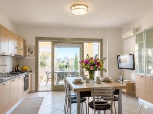 a kitchen with a table with a vase of flowers on it at PIOPPETO EST - Premium Villas in Giulianova