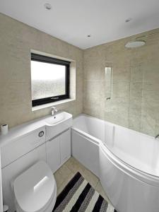 a bathroom with a toilet and a tub and a sink at Modern Contractor House - Lockable Gated Parking in Kiveton Park +23 photos