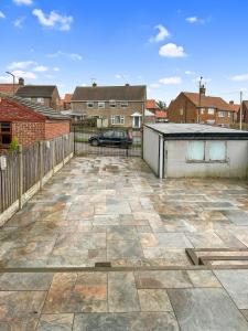 a patio with a fence and a car in a yard at Modern Contractor House - Lockable Gated Parking in Kiveton Park