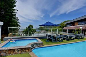 a pool with a table and chairs and an umbrella at Baywater Village by MyResorts in Sedgefield