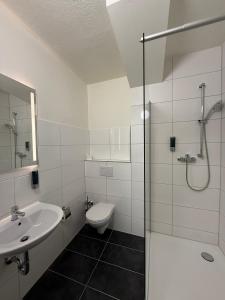 a bathroom with a sink and a toilet and a shower at Shin Central Self-Check-in in Essen +11 photos