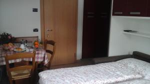 Zimmer mit einem Tisch, einem Tisch und einem Bett in der Unterkunft Cèsa Raggio di Sole in Arabba