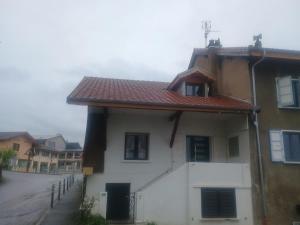 a house with a red roof on a street at Maison neuvecelle in Neuvecelle