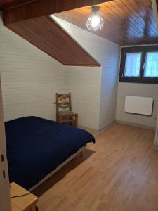 a bedroom with a bed and a chair in a room at Maison neuvecelle in Neuvecelle