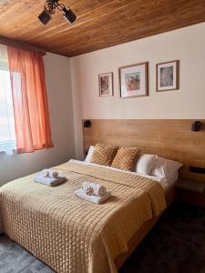 a bedroom with a bed with towels on it at Apartmány Hrabušice in Hrabušice