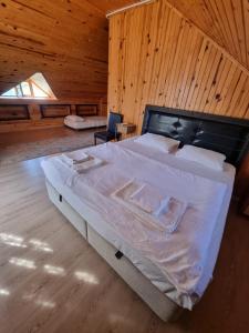 a bedroom with a large bed with a wooden wall at Şahmeran Pansiyon in Kemer