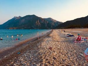 a group of people swimming in the water on a beach at Şahmeran Pansiyon in Kemer