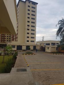 a large building with a parking lot in front of it at Calvin's corner in Kisumu