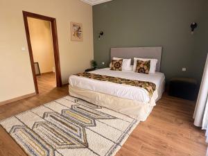 a bedroom with a large bed and a rug at Villa Le Charme de Somone Piscine privée confort & proximité plage in Somone +21 photos