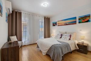 a bedroom with a bed and a desk and two windows at Ria Formosa Pool Heaven in Olhão +20 photos