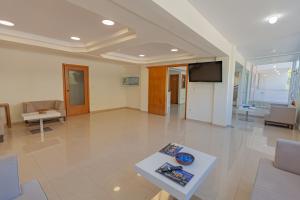 a living room with a table and a tv at Fenix Apartments in Mola Kalyva