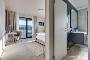 a bedroom with a bed and a bathroom with a sink at Villa Tamaris- 10 mins from Zadar in Zadar