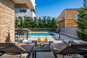 a patio with a table and chairs next to a pool at Villa Tamaris- 10 mins from Zadar in Zadar