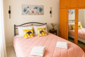 a bedroom with a pink bed with yellow pillows at Sotiris Urban Stay in Xanthi