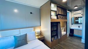a small room with a bed and a bathroom at Duli Beach Farm Hostel in Duli