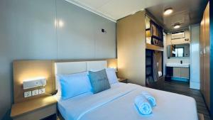 a bedroom with a large white bed with blue pillows at Duli Beach Farm Hostel in Duli