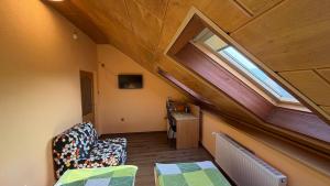 an attic room with a chair and a window at Pension Duel in Ústí nad Labem