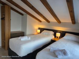 two beds in a hotel room with two lamps at Asteria Houses Samothraki in Samothraki