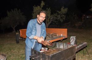 a man is cooking meat on a grill at Pallano in Bomba