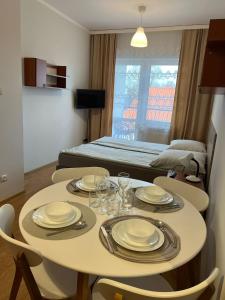 a room with a table with plates and glasses on it at Bursztynowy Brzeg in Sarbinowo