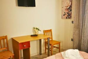 a room with a table and two chairs and a television at Sotiris Urban Stay in Xanthi +5 photos