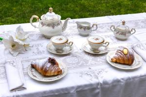 a table with tea cups and croissants on it at La Dimora di B.Cairoli in Ovada