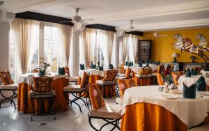 a dining room with tables and chairs with yellow walls at Rohet Garh in Rohat