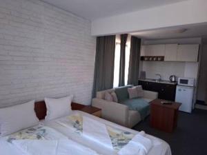 a bedroom with a bed and a living room at Ivet Guest Rooms - Obzor in Obzor