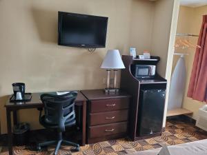a hotel room with a desk and a tv on the wall at Quality Inn Brunswick Cleveland South in Brunswick