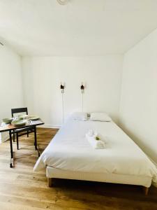 a white bedroom with a bed and a desk at Apparthotel Beauregard 12 cœur de Nantes WIFI in Nantes