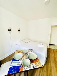 a room with a bed and a table with plates on it at Apparthotel Beauregard 12 cœur de Nantes WIFI in Nantes +1 photo