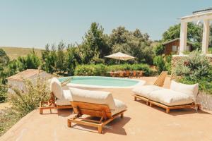 a swimming pool with two lounge chairs and a swimming pool at Monte da Serra de Baixo By CABRA in Sines +35 photos