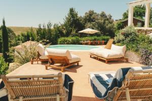 a group of chairs sitting next to a swimming pool at Monte da Serra de Baixo By CABRA in Sines