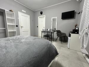 a bedroom with a bed and a table and a television at B&B Art in Silvi Marina