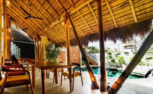 a dining room with a table and chairs and a pool at Hotel Catamaran Bay by Ayur Ayur in Negombo