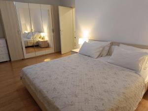 a bedroom with a large bed and a mirror at Apartment T&M in Trogir