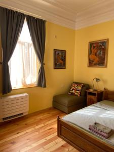 a bedroom with a bed and a couch and a window at Art Studios Elsor in Burgas