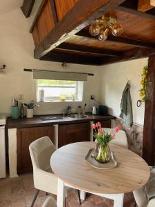 a kitchen with a table with a vase of flowers on it at Tiny Gite La Petite Grue in Louroux-Bourbonnais
