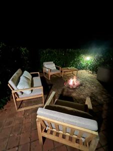 a fire pit with couches and a fire place at night at Tiny Gite La Petite Grue in Louroux-Bourbonnais