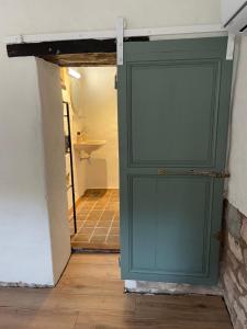a green door in a room with a bathroom at Tiny Gite La Petite Grue in Louroux-Bourbonnais