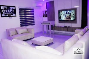 ein Wohnzimmer mit weißen Möbeln und einem Flachbildfernseher in der Unterkunft Stan - Haven Apartments ASOKORO in Asokoro + 20 Fotos