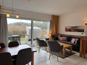 a living room with a couch and a table and chairs at Vierfuss 1A in Hörnum