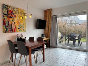a dining room with a table and chairs and a window at Vierfuss 1A in Hörnum +9 photos