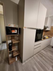 a kitchen with white cabinets and a refrigerator at Casa di ringhiera 1 in Pinerolo