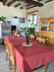 a dining room table with a vase of flowers on it at Entre terre et baie à 15 mn du Mont-Saint-Michel in Pontaubault