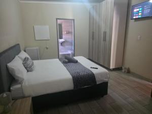 a hotel room with a bed and a television at The Second Tranquilo in Ermelo